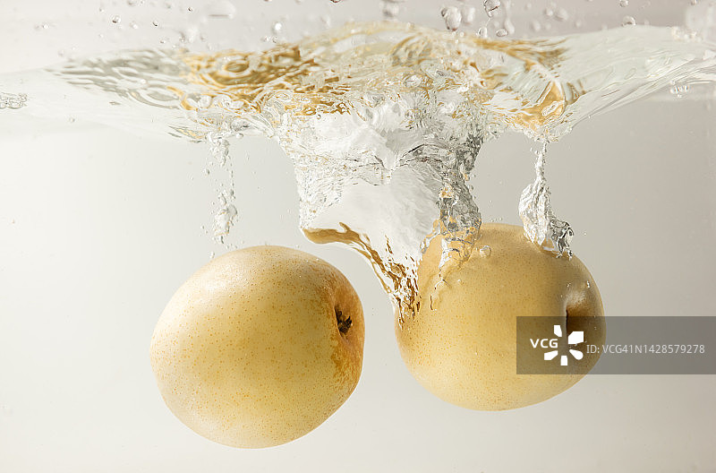 水中飞溅的黄色梨图片素材
