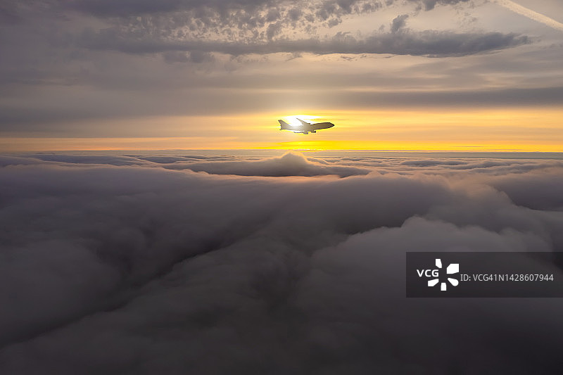 日落时分云层之上的飞机，航空旅行图片素材
