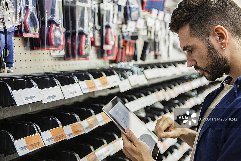 使用平板电脑清点库存的五金店男工人图片素材
