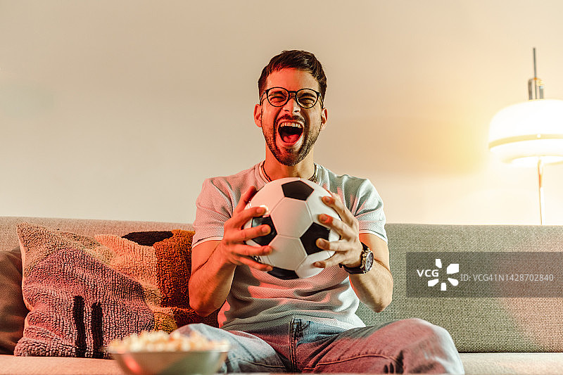 拿着足球欢呼雀跃的兴奋年轻人图片素材