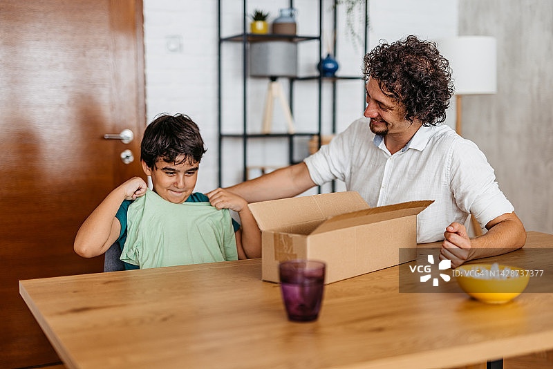 父亲和儿子打开一个纸板箱图片素材