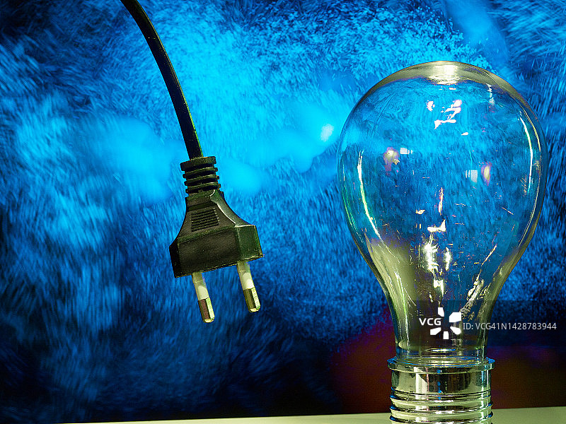 正在发光的灯泡和电缆，能源消耗概念图片素材