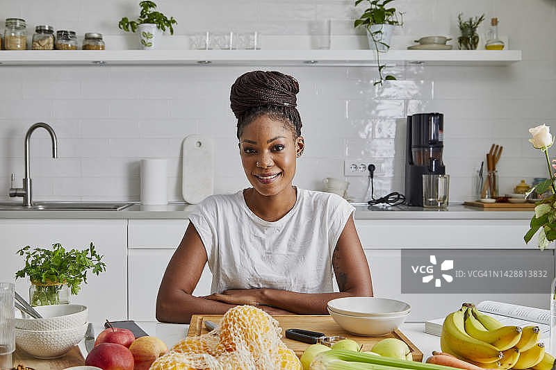在厨房里的年轻漂亮的黑人女性肖像，代表着健康的生活方式图片素材