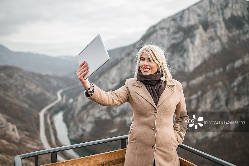 漂亮女人通过视频通话向朋友展示观点的美丽景色图片素材