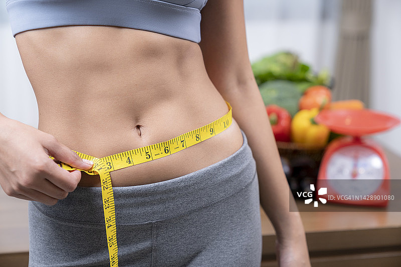 测量腰围的苗条女人图片素材