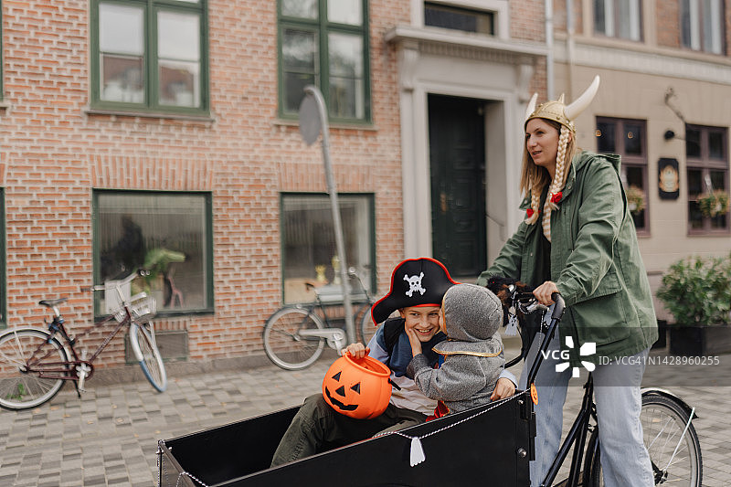 两个小男孩骑着货运自行车去万圣节探险图片素材