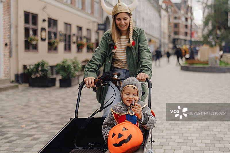 骑着货运自行车进行万圣节寻宝的小男孩图片素材