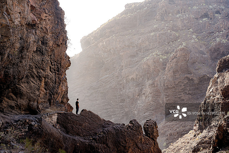 独自一人观察光线进入峡谷的徒步者，特内里费岛图片素材
