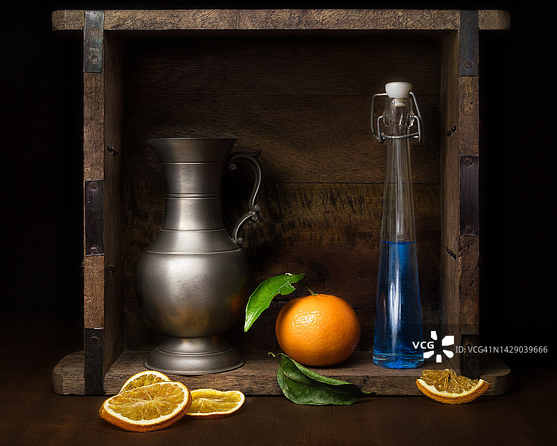 锡制花瓶、玻璃瓶和橘子静物图片素材