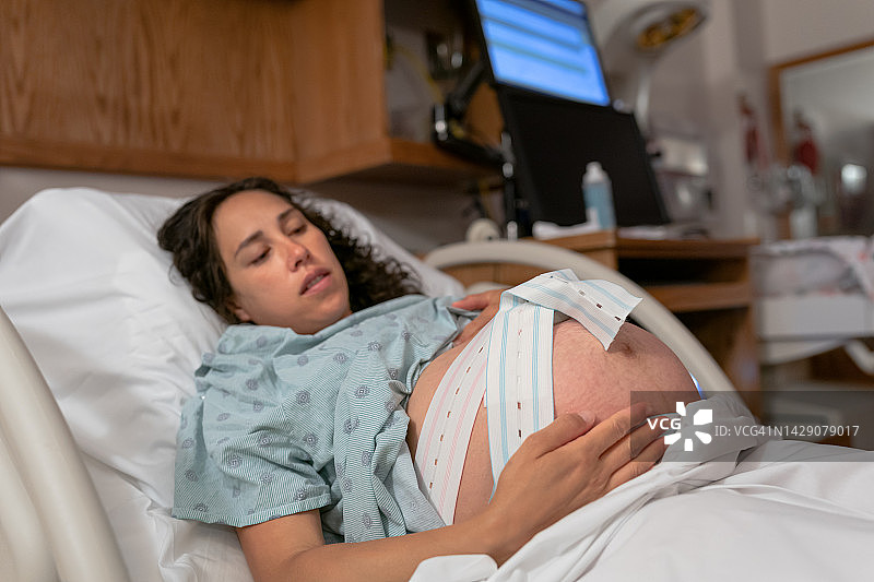 在医院病床上监测宫缩和心跳的孕妇图片素材
