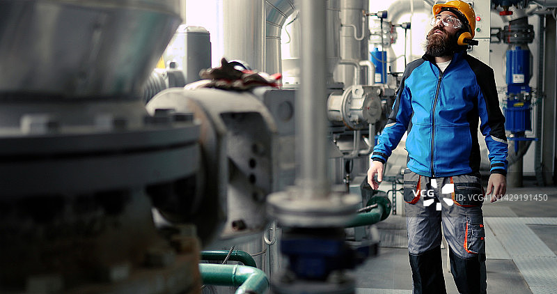 专注的供热厂工人在防护服里工作图片素材