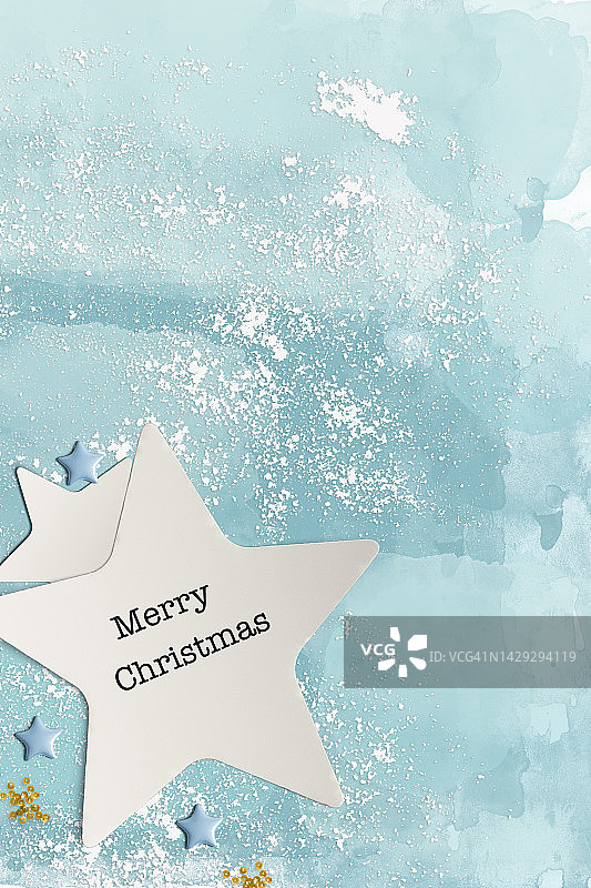 用剪纸制作的圣诞贺卡：蓝色背景中的白色纸星星图片素材