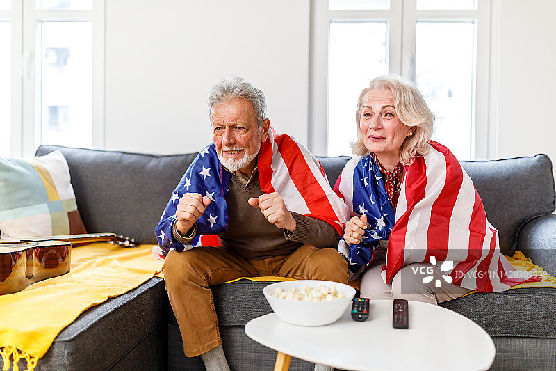 一对年长的夫妇在舒适的公寓里观看体育比赛图片素材
