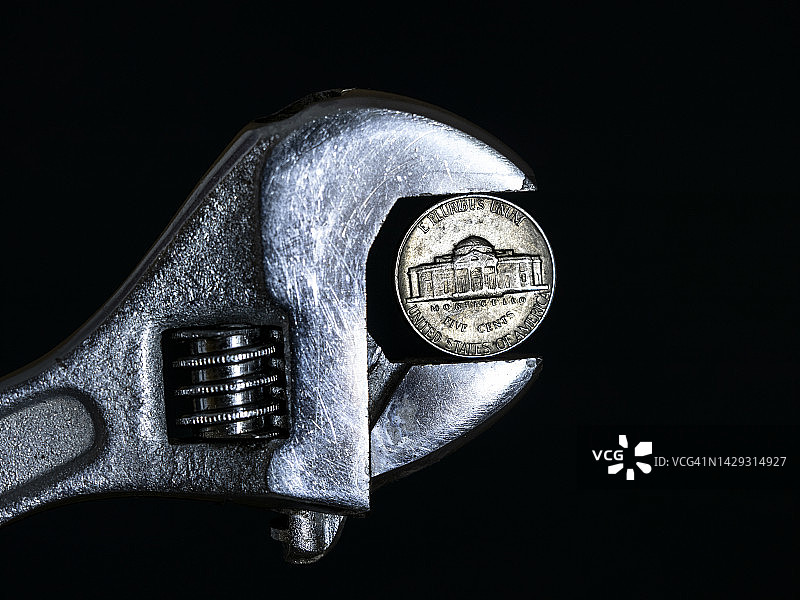 扳手夹着美元硬币图片素材