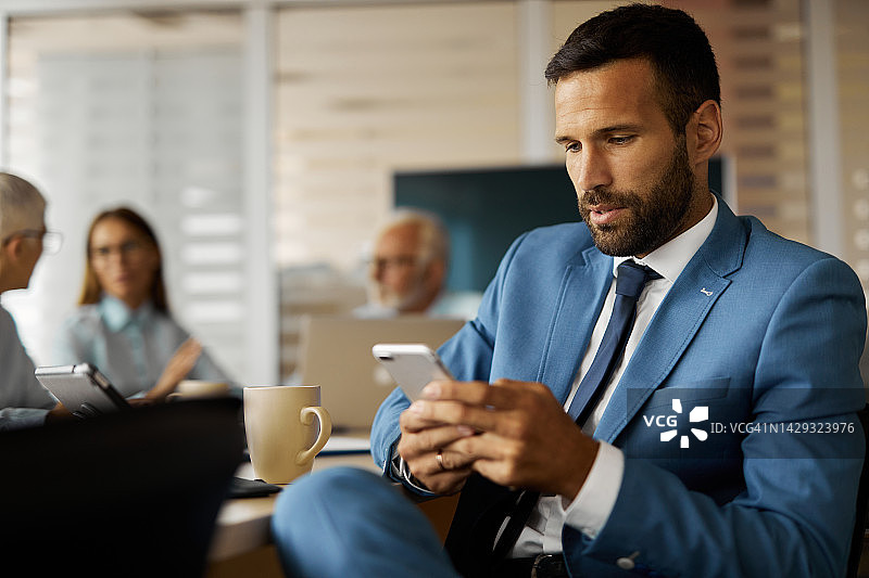 在办公室使用手机的年轻商人图片素材