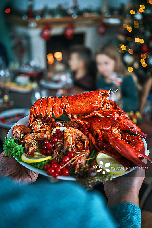 含三文鱼片、扇贝、龙虾、虾和圣诞蛋糕的圣诞晚餐图片素材