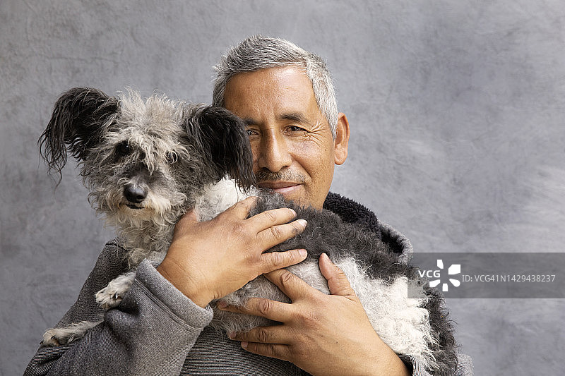 男人抱着他的宠物狗图片素材