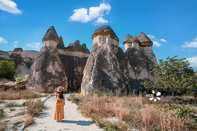 旅行中的年轻女孩正在内夫谢希尔卡帕多西亚的帕夏贝山谷的僧侣谷看着童话般的烟囱图片素材