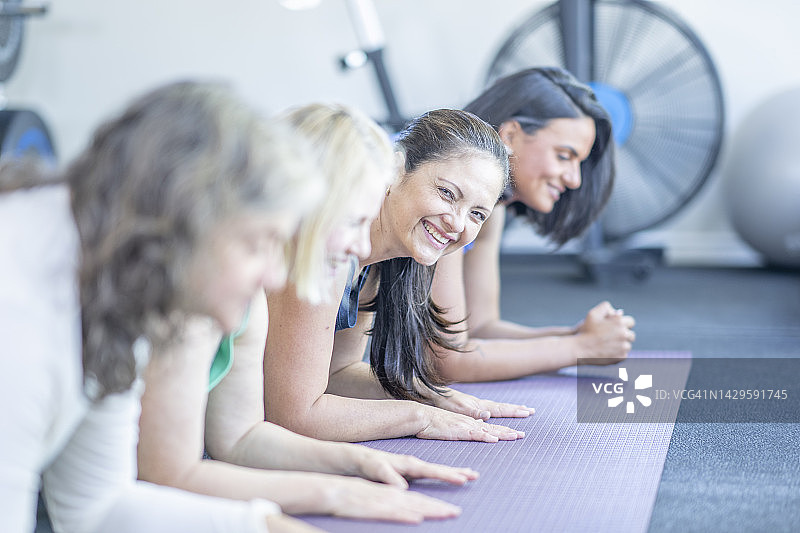 女性在健身课上做平板支撑图片素材