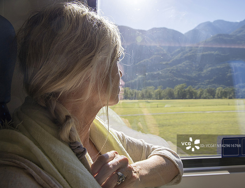 望着火车窗外的中年妇女侧面照图片素材