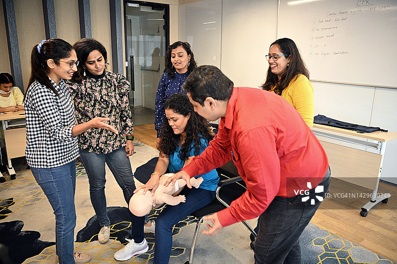 女子在心肺复苏急救培训中对儿童模型进行海姆立克急救图片素材