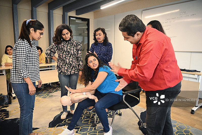 女子在心肺复苏急救培训中对儿童模型进行海姆立克急救图片素材