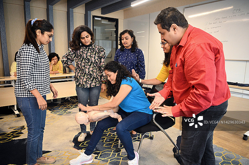 女子在心肺复苏急救培训中对儿童模型进行海姆立克急救图片素材