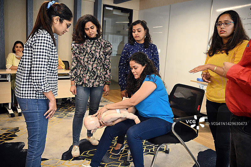 女子在心肺复苏急救培训中对儿童模型进行海姆立克急救图片素材