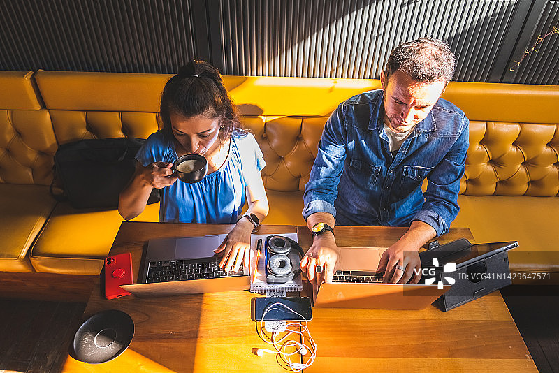 在咖啡馆一起使用笔记本电脑的办公开发者图片素材