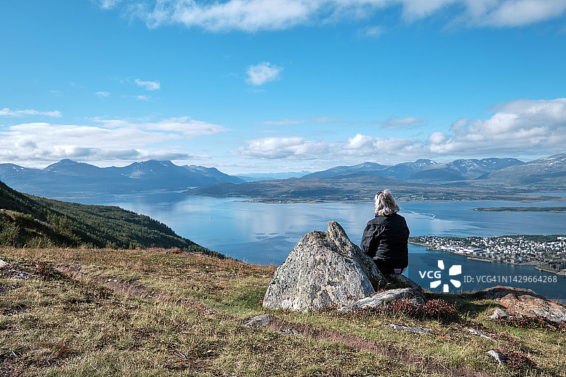 在挪威北部特罗姆瑟欣赏风景的灰发妇女图片素材