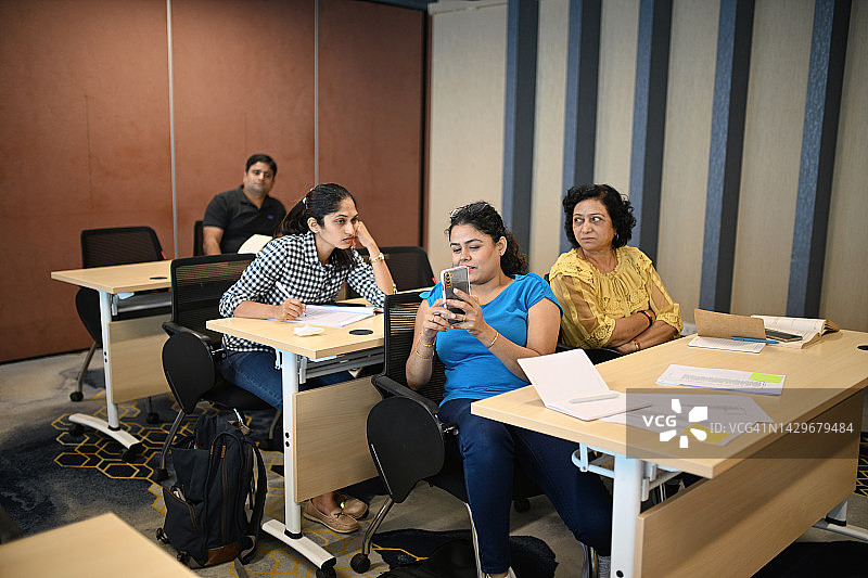 研讨会期间，参与者在教室里互相讨论图片素材