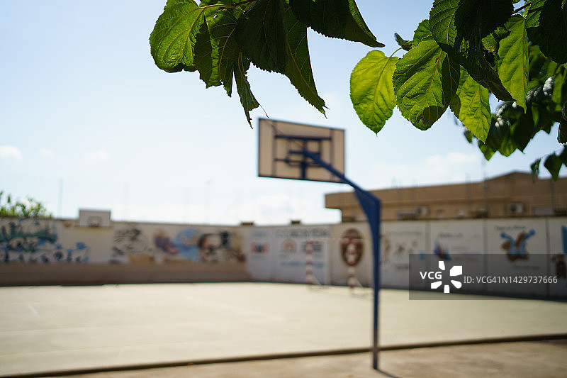 户外中学的运动场绿色区域，有篮球架和手球或足球球门图片素材