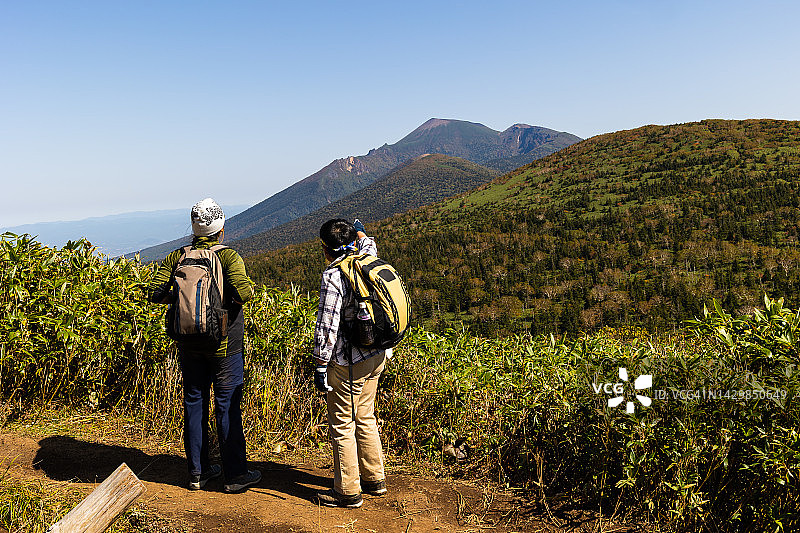 两位女徒步旅行者停下来欣赏山景图片素材