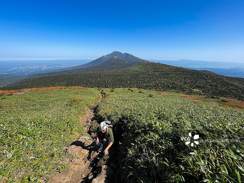 中年女人在晴朗的阳光下登山图片素材
