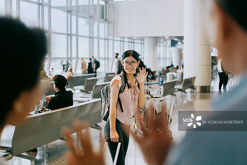 年轻女孩在登机前与父母告别图片素材