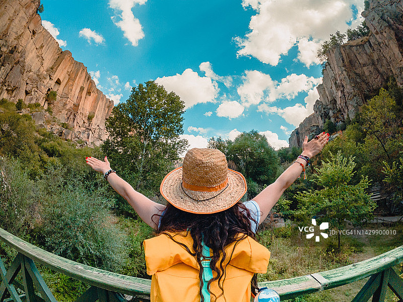 在土耳其阿克萨赖的伊赫拉拉山谷佩里斯特雷马山谷桥梁上张开双臂的年轻旅行女孩图片素材