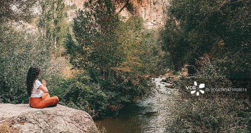 在土耳其阿克萨赖的伊赫拉拉山谷冥想做瑜伽的年轻旅行者女孩图片素材