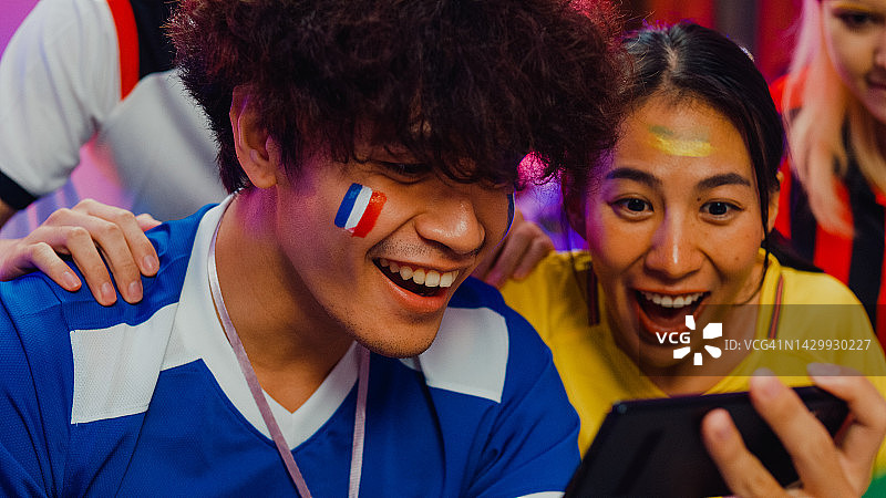 亚洲青少年在沙发上看足球比赛图片素材