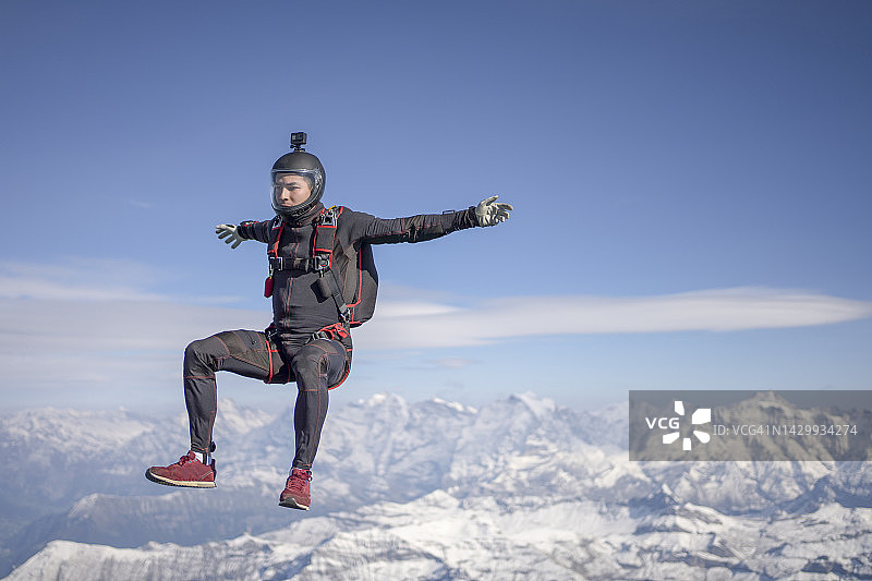 跳伞运动员在雪山上方自由飞翔图片素材