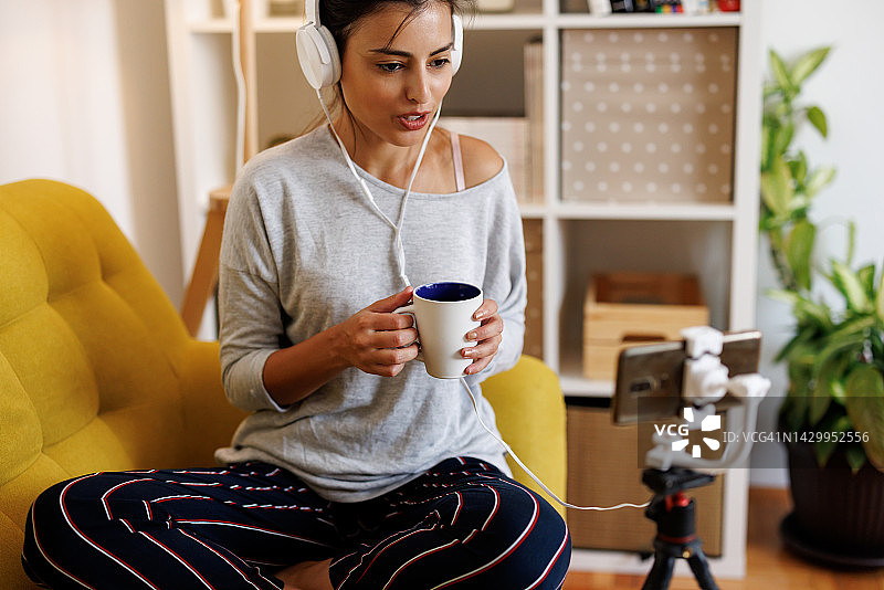 年轻女人在家用手机直播生活指导视频图片素材