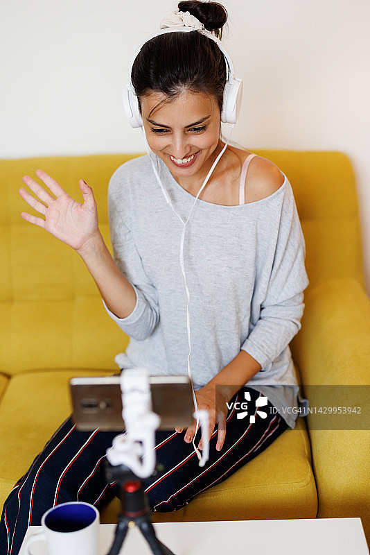 年轻女性网红在家与社交媒体粉丝进行电话交谈图片素材