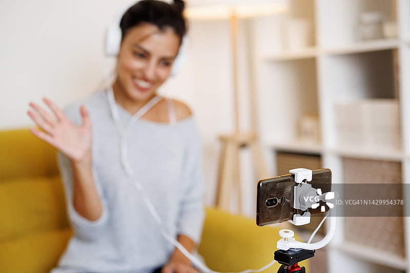 年轻女性网红在家与社交媒体粉丝进行电话交谈图片素材