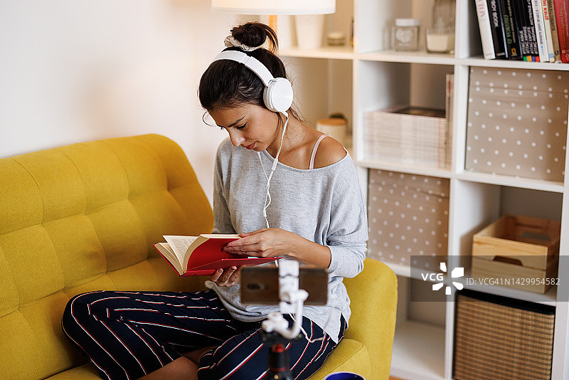 年轻女子在家直播并推广阅读图片素材