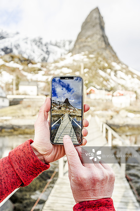 游客用智能手机拍摄挪威的山脉图片素材