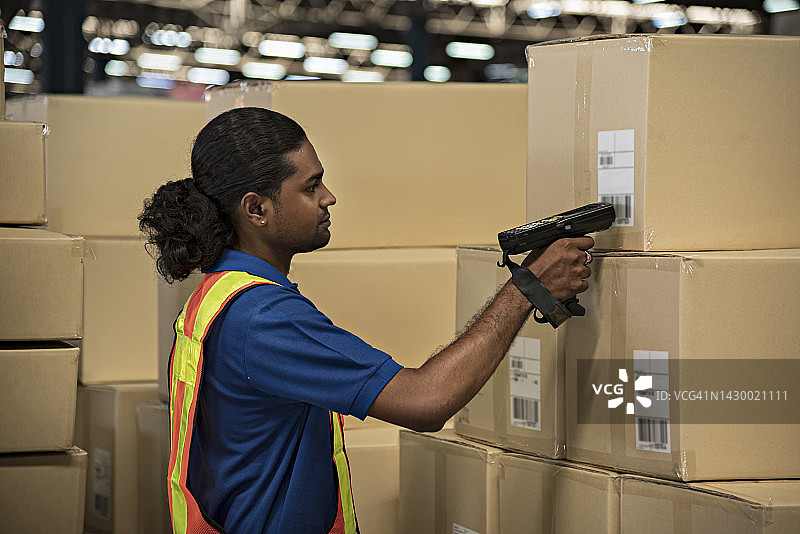 仓库工人使用条形码扫描机检查库存图片素材