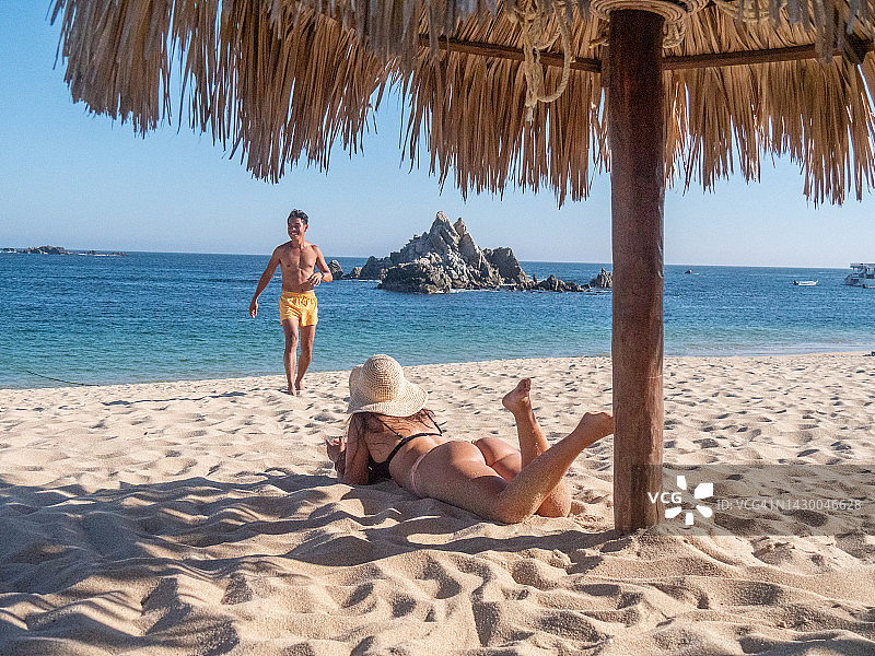 多种族夫妇在墨西哥海滩上享受日光浴图片素材