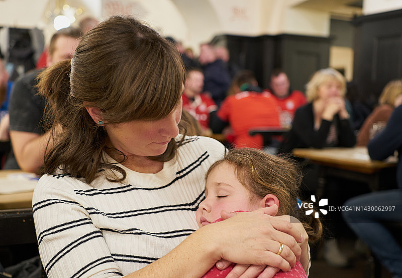 德国巴伐利亚慕尼黑：棕发白人妇女在室内抱着一个女孩图片素材