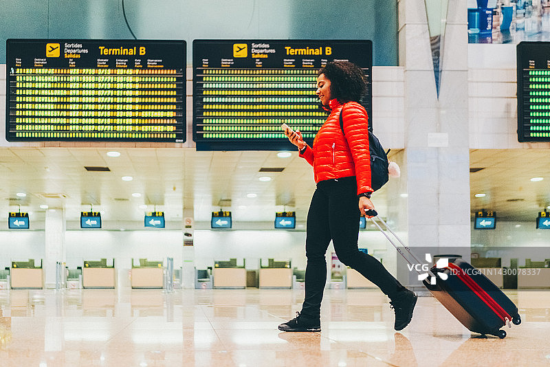 在机场航站楼使用智能手机的女人图片素材
