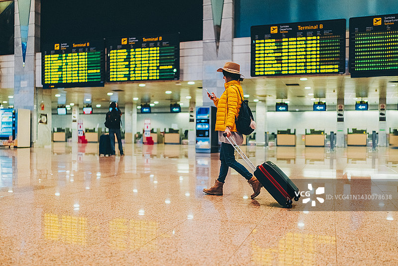 在机场航站楼使用智能手机的女人图片素材