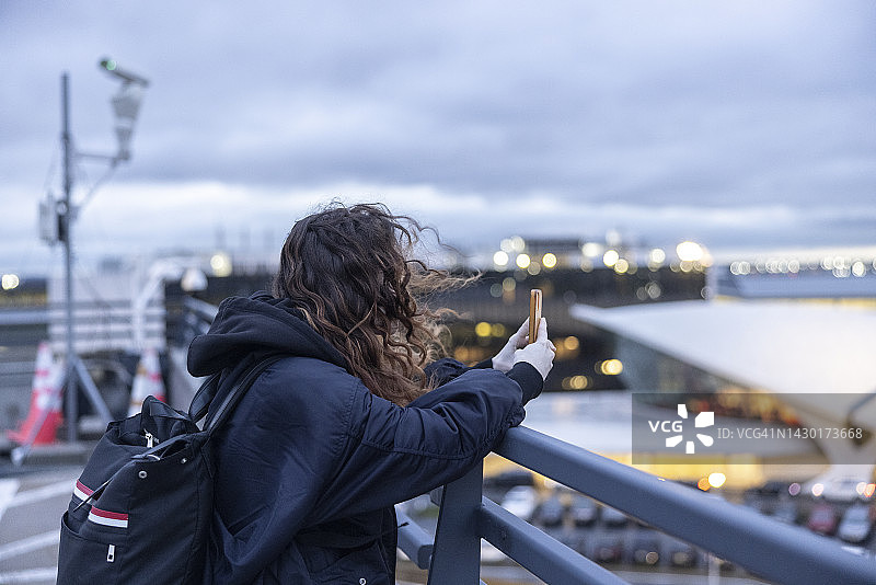 白人女性在机场用智能手机拍摄照片图片素材